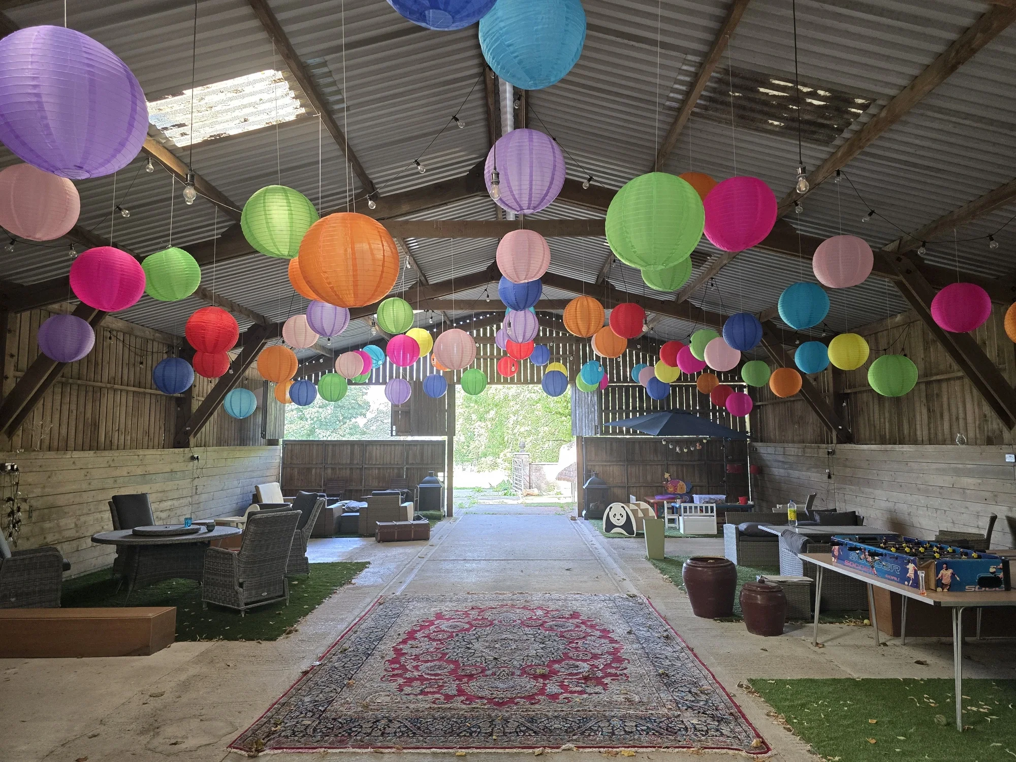 Paper lanterns strung through the barn, ready for a wedding feast
